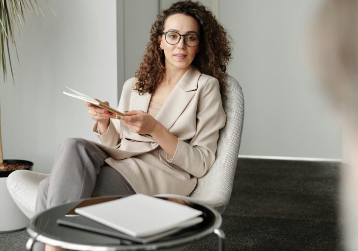 A professional woman in an office setting conducting an interview with confidence.